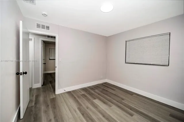 an empty room with wooden floor and closet