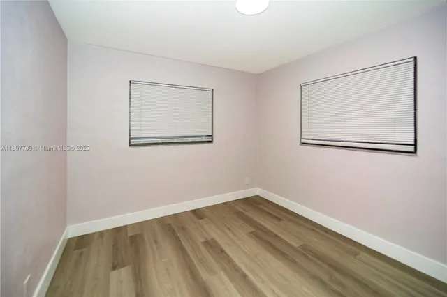 a view of a room with wooden floor and a window