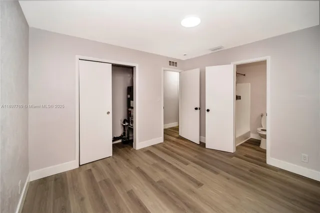an empty room with wooden floor and closet