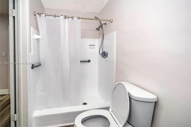 a bathroom with a toilet and a shower