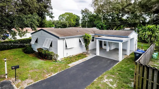 a view of house with garden space and car parked