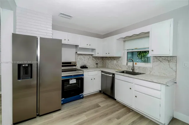a kitchen with a sink stainless steel appliances and cabinets