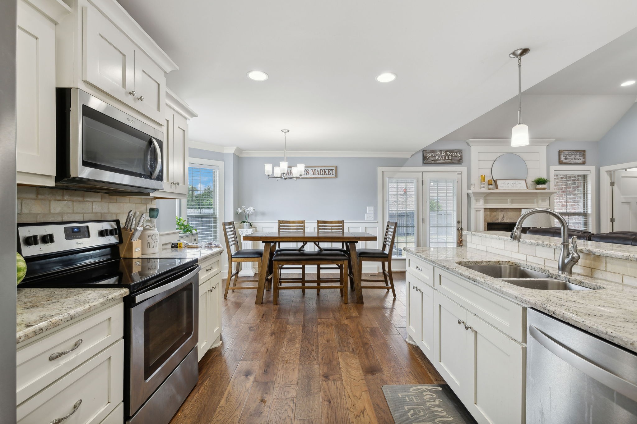 101 Flat Woods Road Lebanon, TN 37090 - Photo 22 of 55 a kitchen with stainless steel appliances kitchen island granite countertop a stove top oven a sink a dining table and chairs with wooden floor