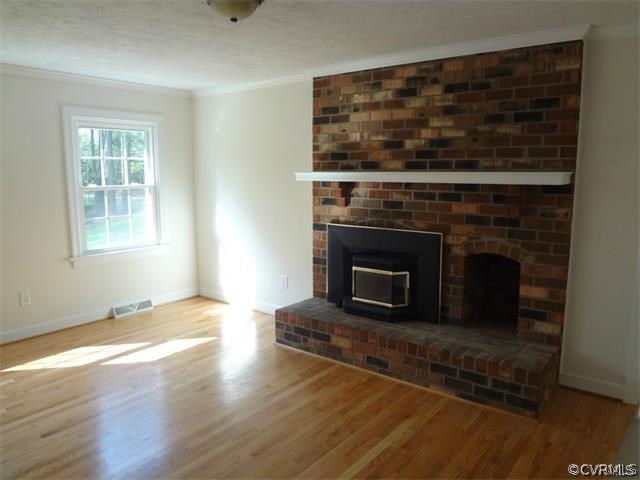 8074 Peaks Road Hanover, VA 23069 - Photo 2 of 28 an empty room with wooden floor fireplace and windows