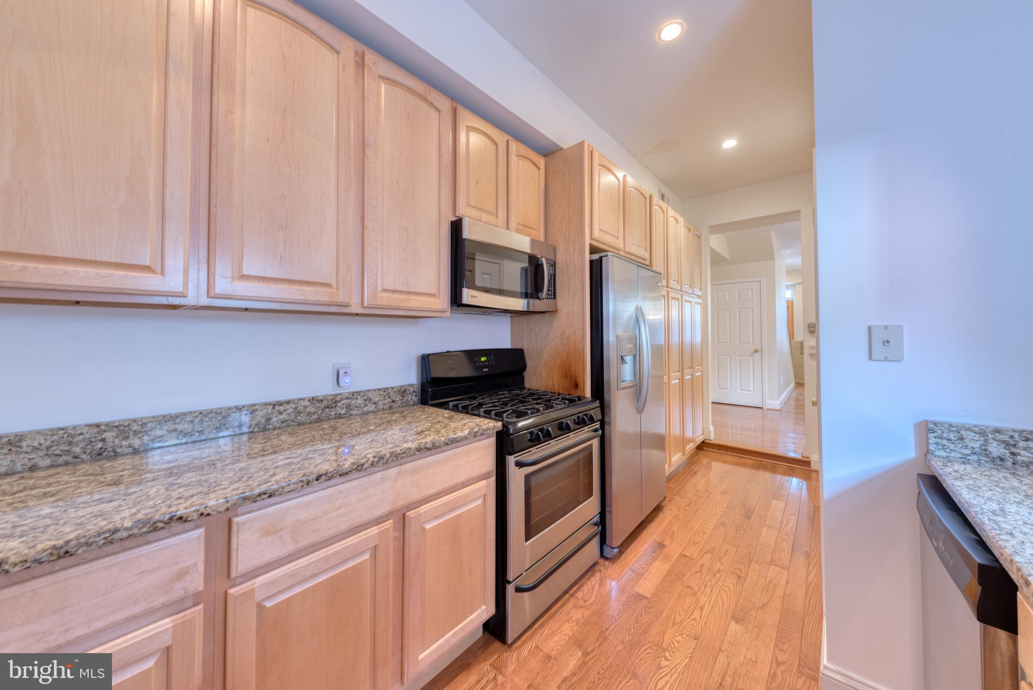 1818 Bank Street Baltimore, MD 21231 - Photo 9 of 20 a kitchen with stainless steel appliances granite countertop a stove a sink and a refrigerator