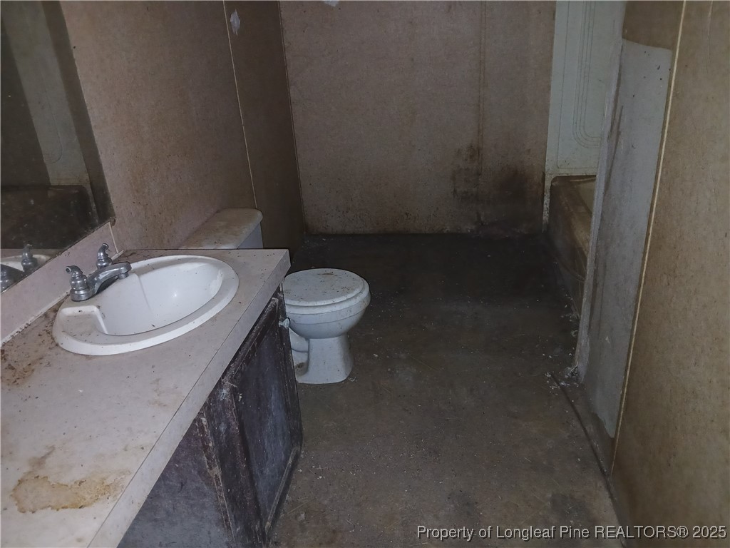 1329 McArthur Road Maxton, NC 28364 - Photo 9 of 12 a bathroom with a sink a toilet and a mirror