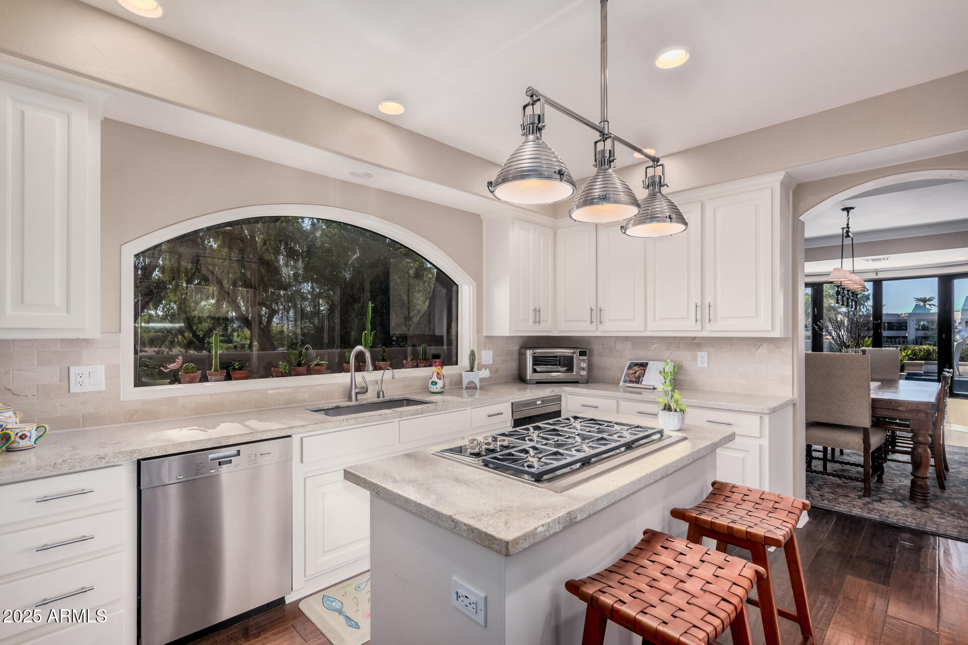 7878 East Gainey Ranch Road, Unit 41 Scottsdale, AZ 85258 - Photo 14 of 46 a kitchen with a stove a sink dishwasher a dining table and chairs with wooden floor