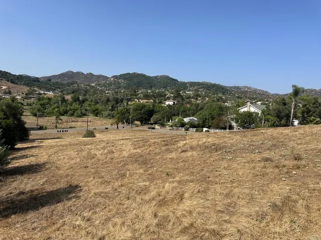 a view of a dry yard with mountains in the background