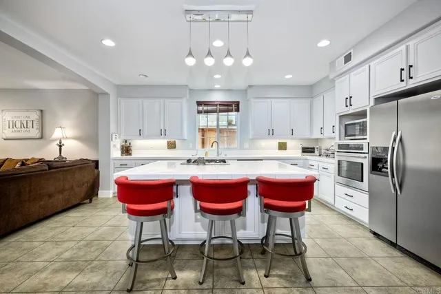 a kitchen with granite countertop a sink refrigerator and cabinets