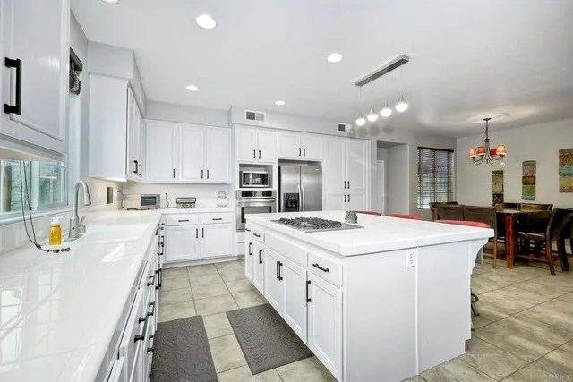 a large kitchen with kitchen island a stove a table a refrigerator a stove a dining table and chairs