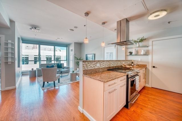 a kitchen with a stove and wooden floor