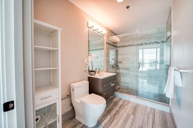 a bathroom with a granite countertop sink toilet a mirror and shower