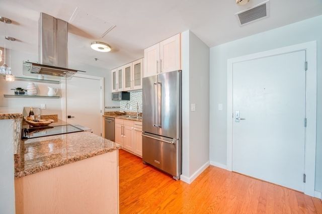 a kitchen with stainless steel appliances granite countertop a refrigerator and a stove