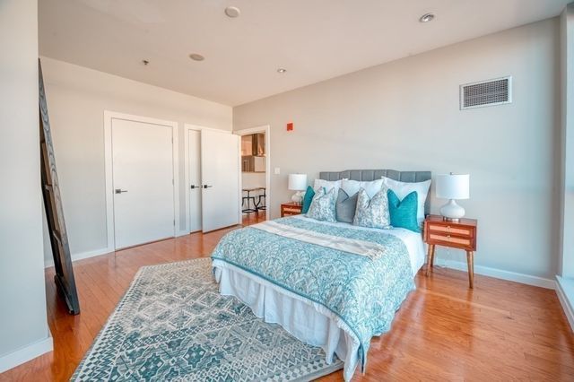 a bedroom with a bed and wooden floor