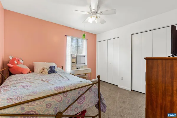 a bedroom with a bed a window and a flat screen tv