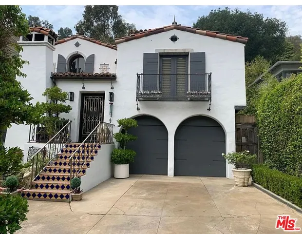 a front view of a house with plants