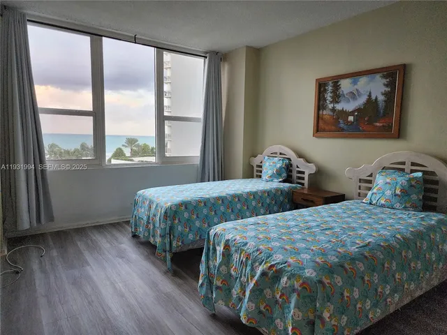 a bedroom with two beds and a large window