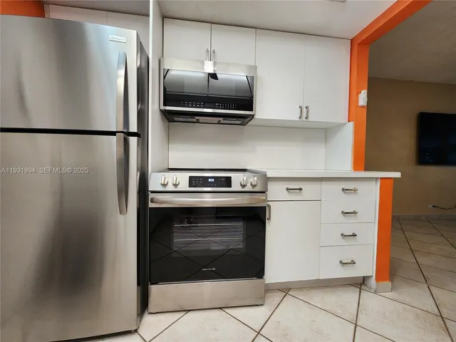 a kitchen with stainless steel appliances a refrigerator stove and microwave