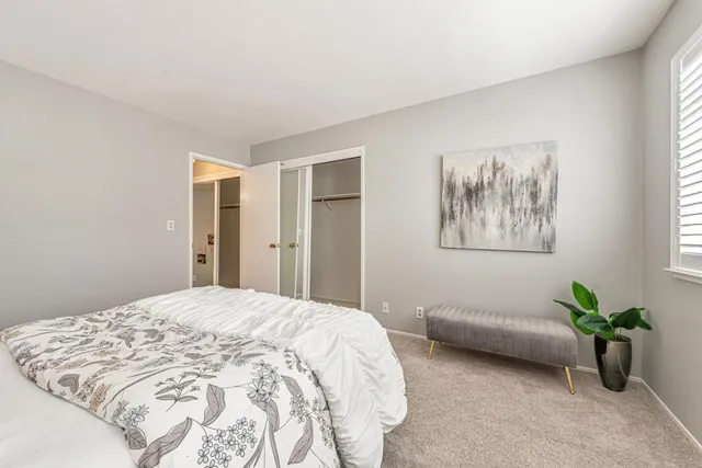 a spacious bedroom with a bed and a painting on the wall