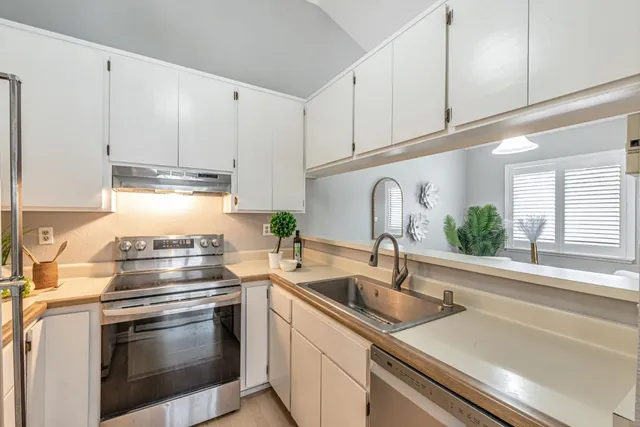 a kitchen with granite countertop a sink stainless steel appliances and cabinets