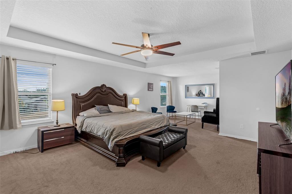 1641 Regal River Circle Ocoee, FL 34761 - Photo 25 of 42 a spacious bedroom with a bed and a tv