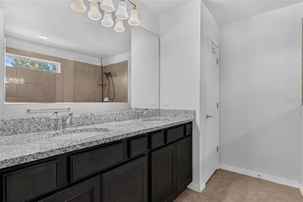 a en suite bathroom with a granite countertop sink and a mirror