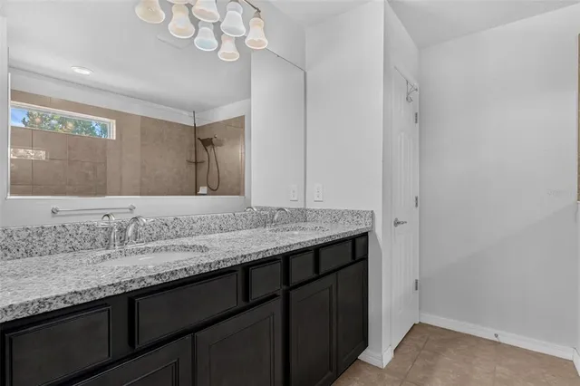 a en suite bathroom with a granite countertop sink and a mirror