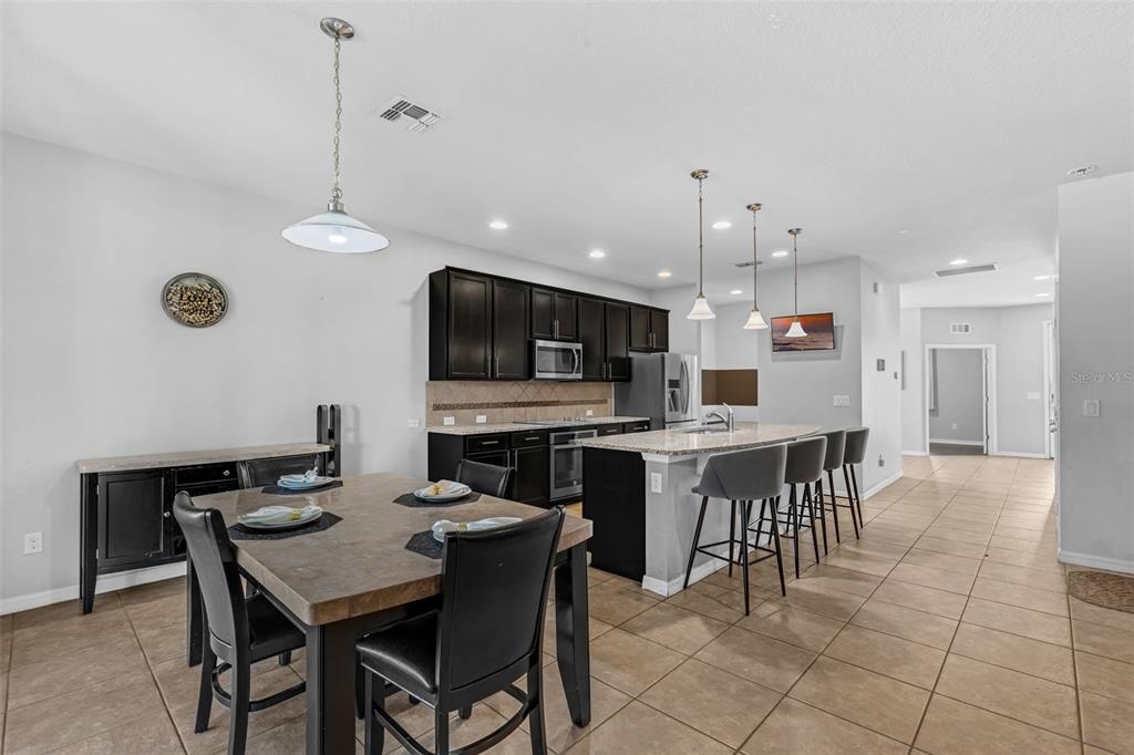 1641 Regal River Circle Ocoee, FL 34761 - Photo 6 of 42 a kitchen with a dining table chairs and white cabinets