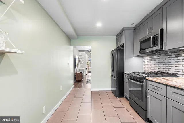 a kitchen with stainless steel appliances granite countertop a refrigerator and a stove top oven