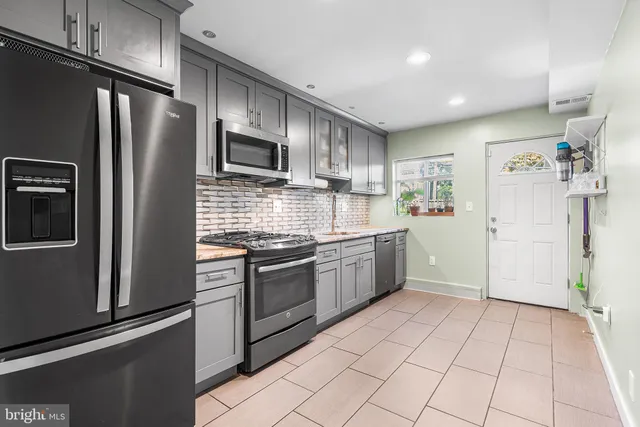 a kitchen with stainless steel appliances granite countertop a refrigerator and a stove top oven