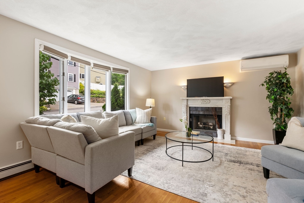 226 Pine Hill Circle Waltham, MA 02451 - Photo 5 of 28 a living room with furniture a large window and a fireplace