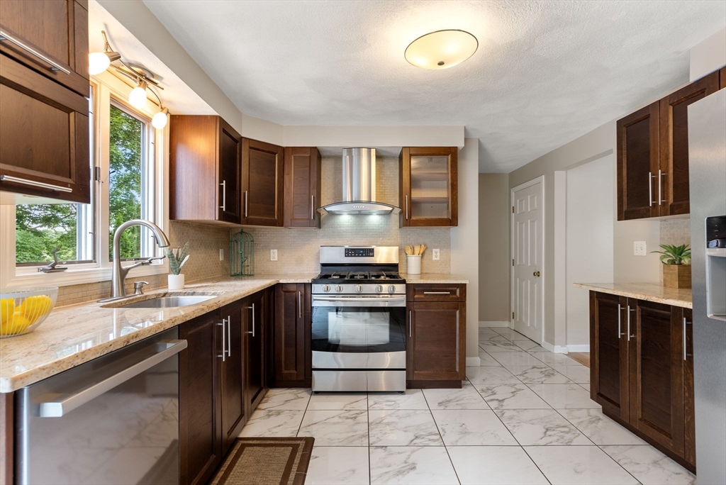 226 Pine Hill Circle Waltham, MA 02451 - Photo 7 of 28 a kitchen with stainless steel appliances granite countertop a stove a sink and a microwave