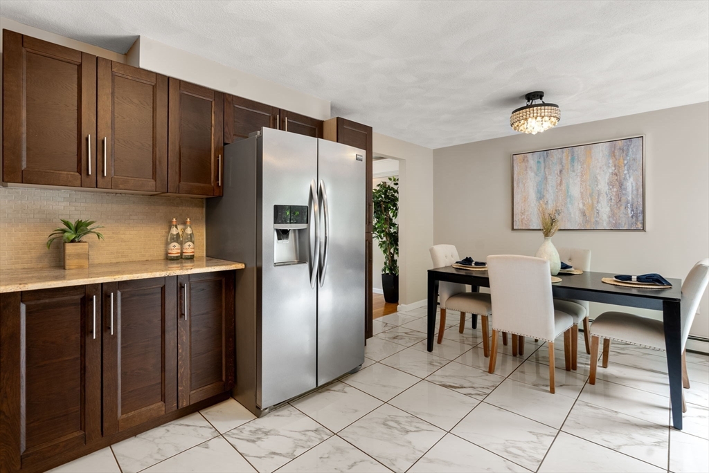 226 Pine Hill Circle Waltham, MA 02451 - Photo 9 of 28 a kitchen with granite countertop a refrigerator and a stove top oven