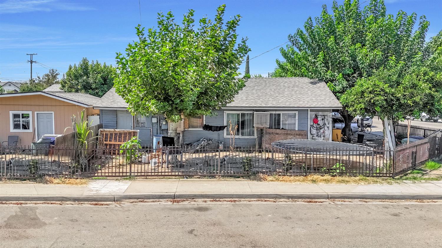 255 J Street Parlier, CA 93648 - Photo 12 of 19 a front view of house with yard and trees in the background