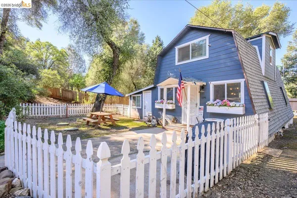 a view of a house with wooden fence next to a yard