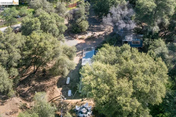 an aerial view of house with yard and mountain view in back