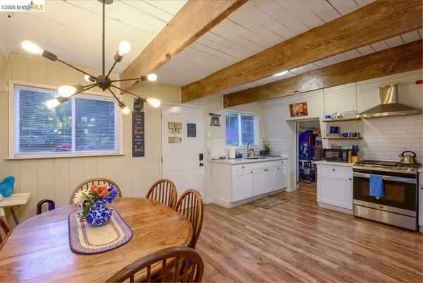 a kitchen with stainless steel appliances granite countertop a stove a kitchen island with a dining table and chairs