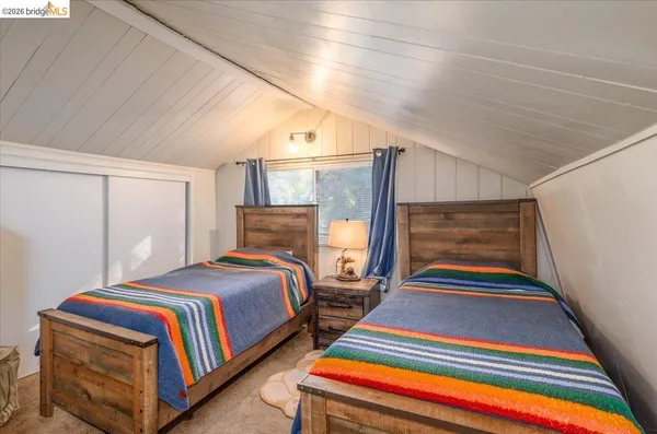 a bedroom with a bed a mirror on dresser and a chandelier