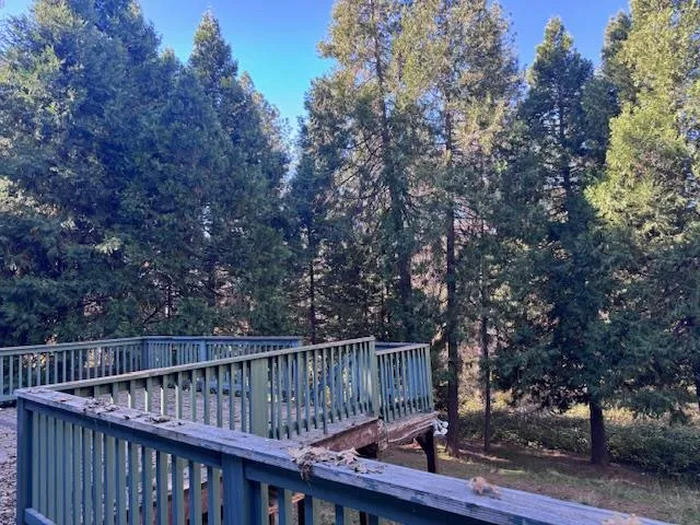 a view of balcony with wooden fence and trees