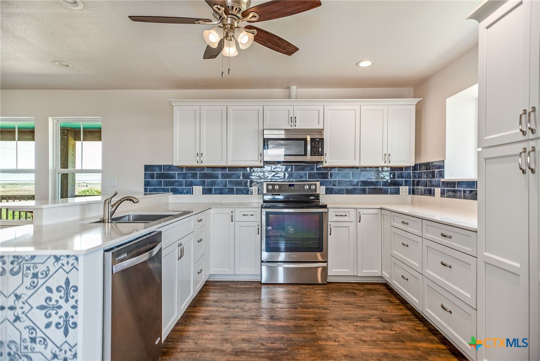211 Taylor Avenue Port O'Connor, TX 77982 - Photo 28 of 43 a kitchen with stainless steel appliances granite countertop a sink and stove top oven