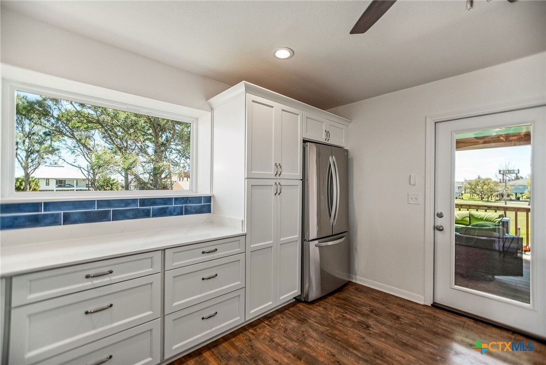 211 Taylor Avenue Port O'Connor, TX 77982 - Photo 30 of 43 a kitchen with white cabinets and wooden floor