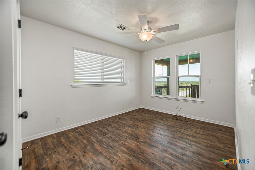 211 Taylor Avenue Port O'Connor, TX 77982 - Photo 40 of 43 a view of an empty room with a window and wooden floor
