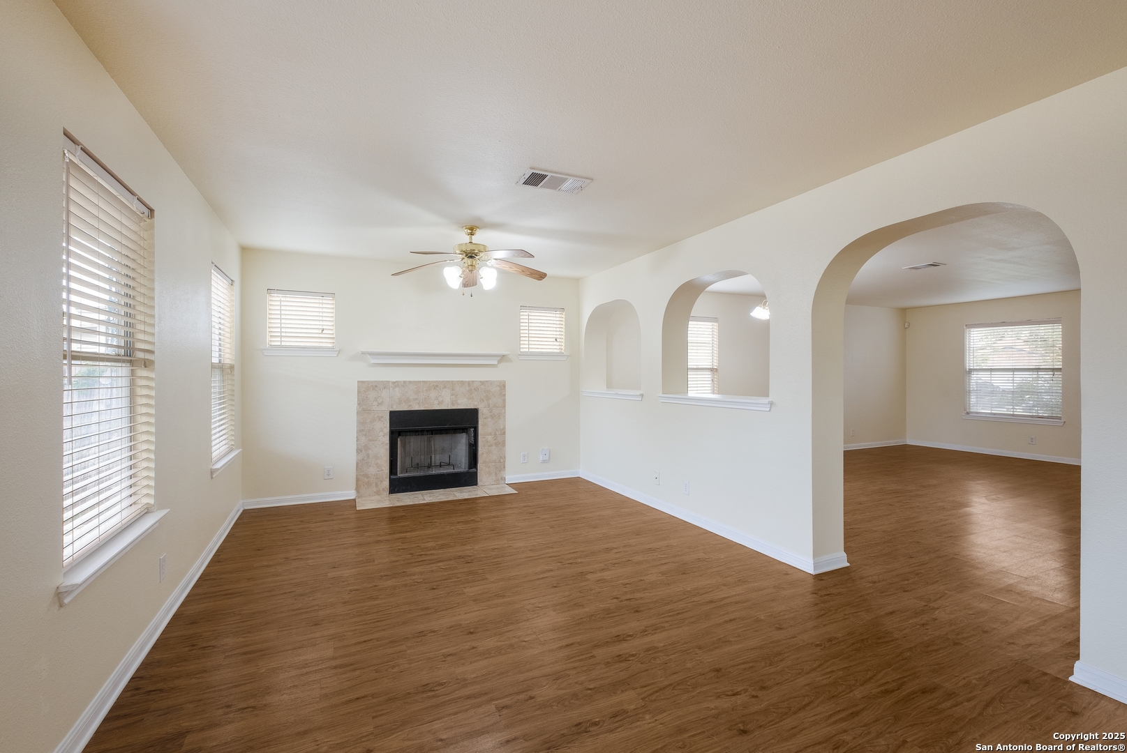 4946 Orchid Star San Antonio, TX 78218 - Photo 5 of 11 an empty room with wooden floor fireplace and windows
