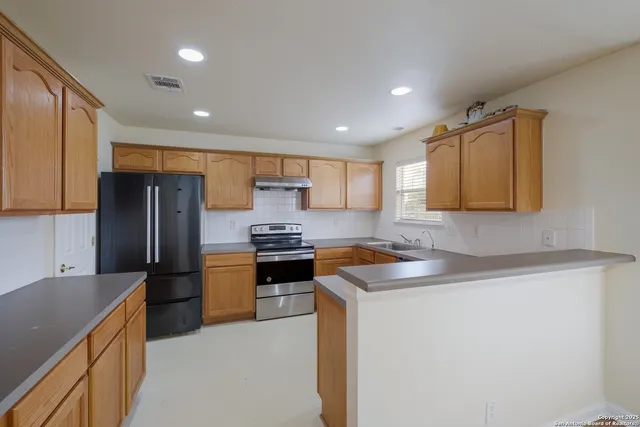 a kitchen with stainless steel appliances granite countertop a refrigerator sink and stove