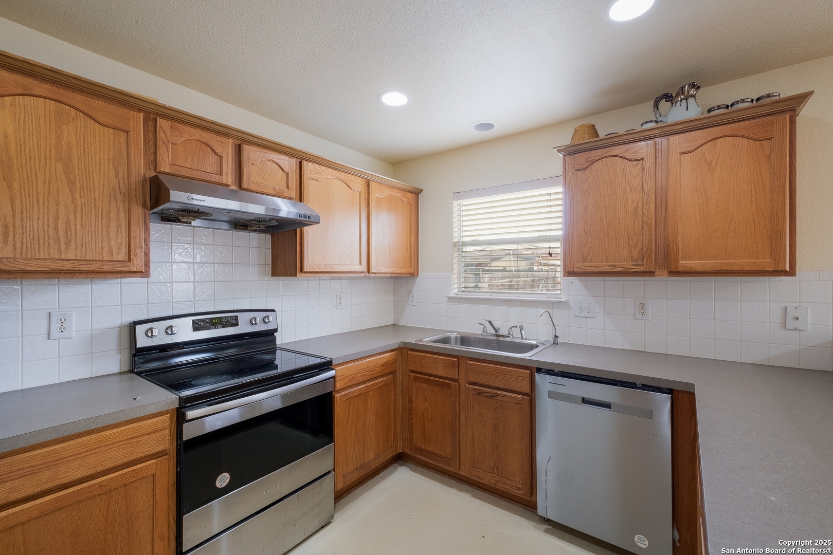 4946 Orchid Star San Antonio, TX 78218 - Photo 7 of 11 a kitchen with stainless steel appliances granite countertop a sink stove and cabinets