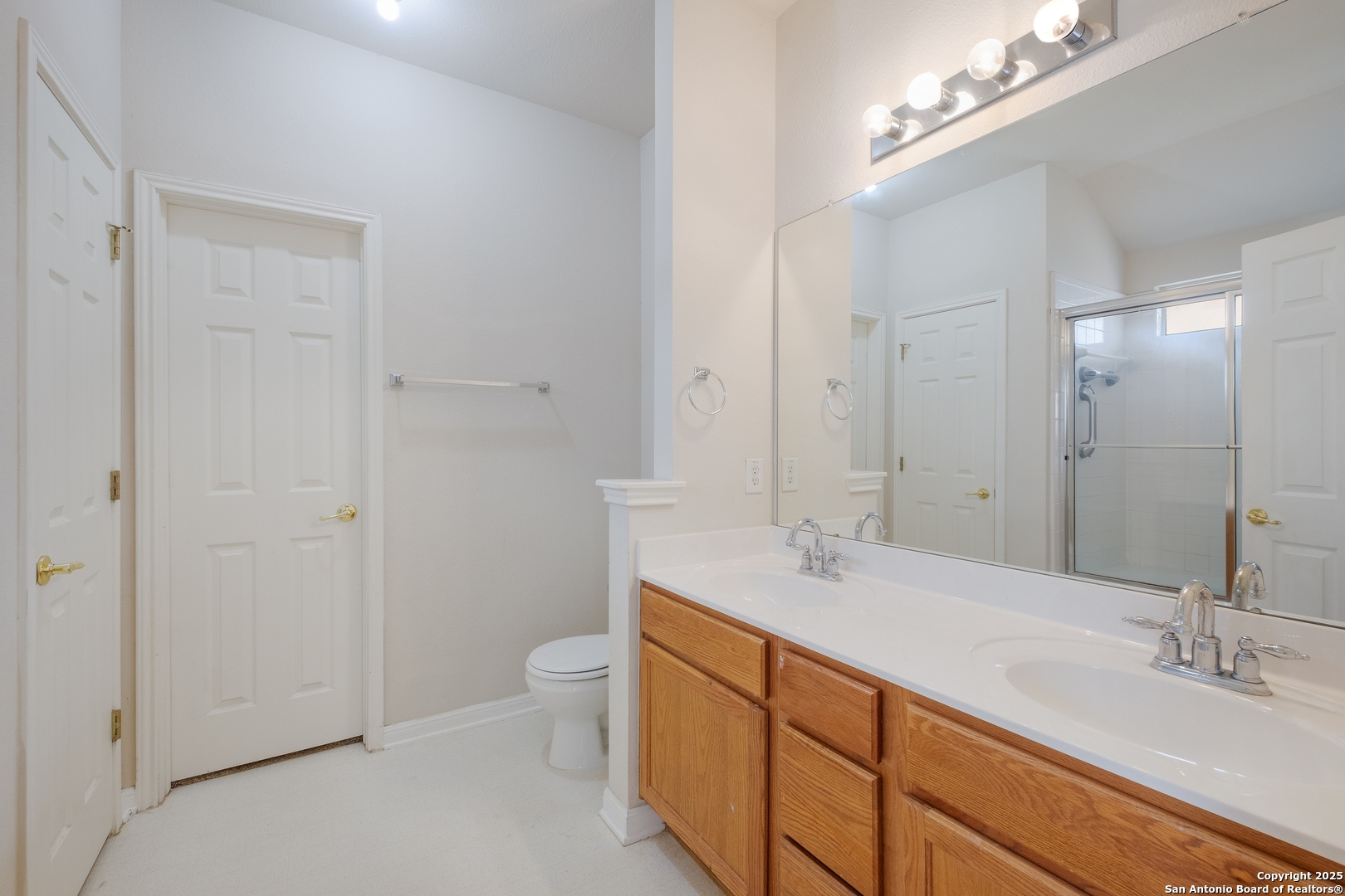 4946 Orchid Star San Antonio, TX 78218 - Photo 9 of 11 a spacious bathroom with a granite countertop sink a toilet and a mirror