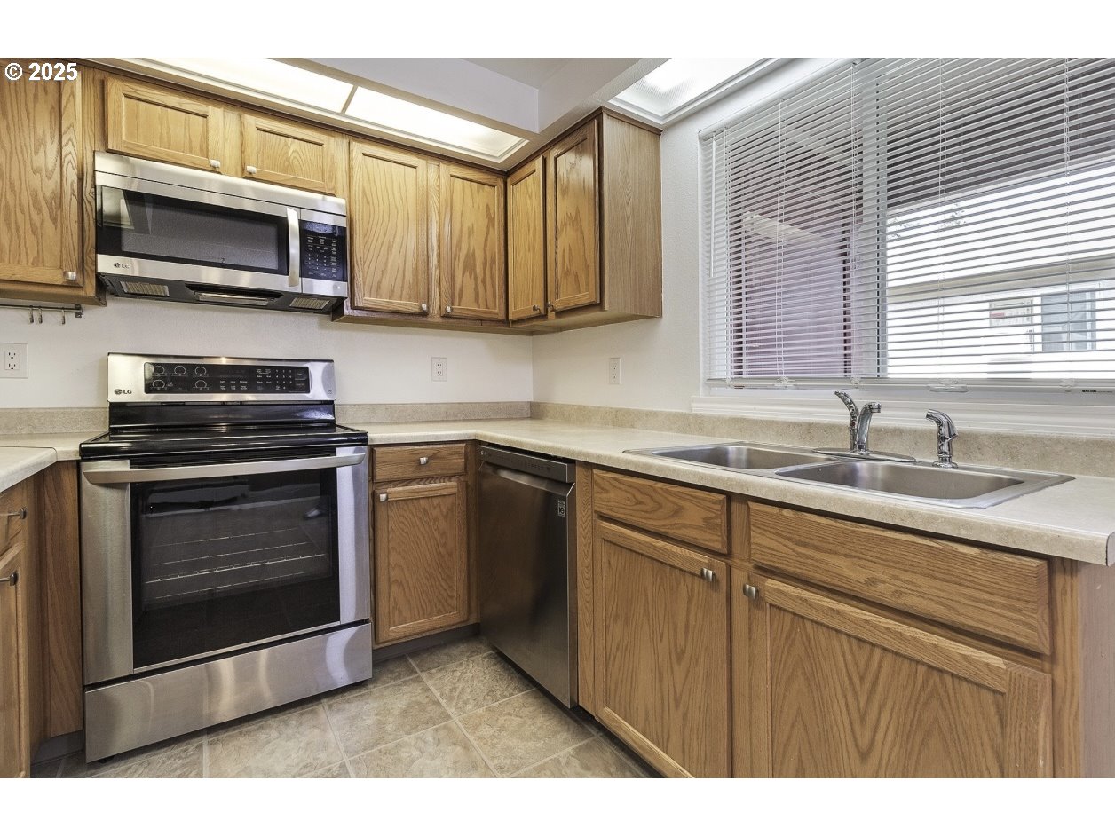 1470 Southeast Walnut Street, Unit 210 Hillsboro, OR 97123 - Photo 7 of 16 a kitchen with stainless steel appliances granite countertop a stove microwave and sink