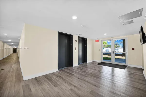 a view of an empty room with wooden floor
