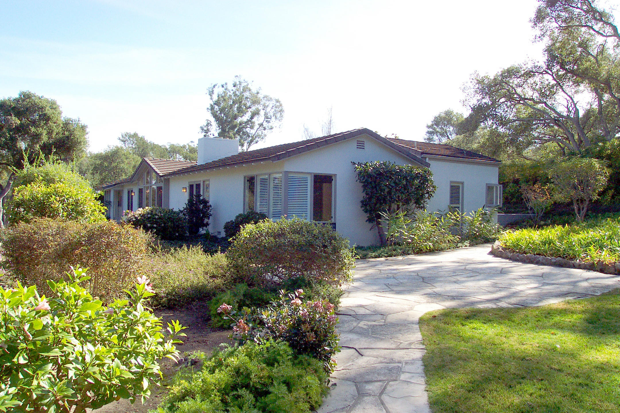 a view of a house with a small yard and plants