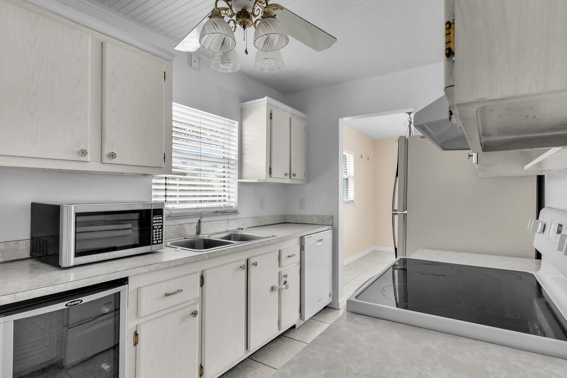 40 High Point Road, Unit F206 Tavernier, FL 33070 - Photo 16 of 24 a kitchen with stainless steel appliances kitchen island granite countertop a refrigerator a sink and white cabinets
